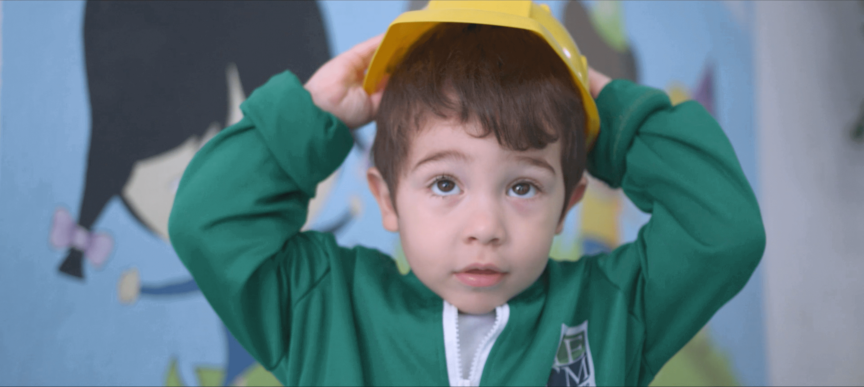 Imagem de menino com chapéu amarelo.
